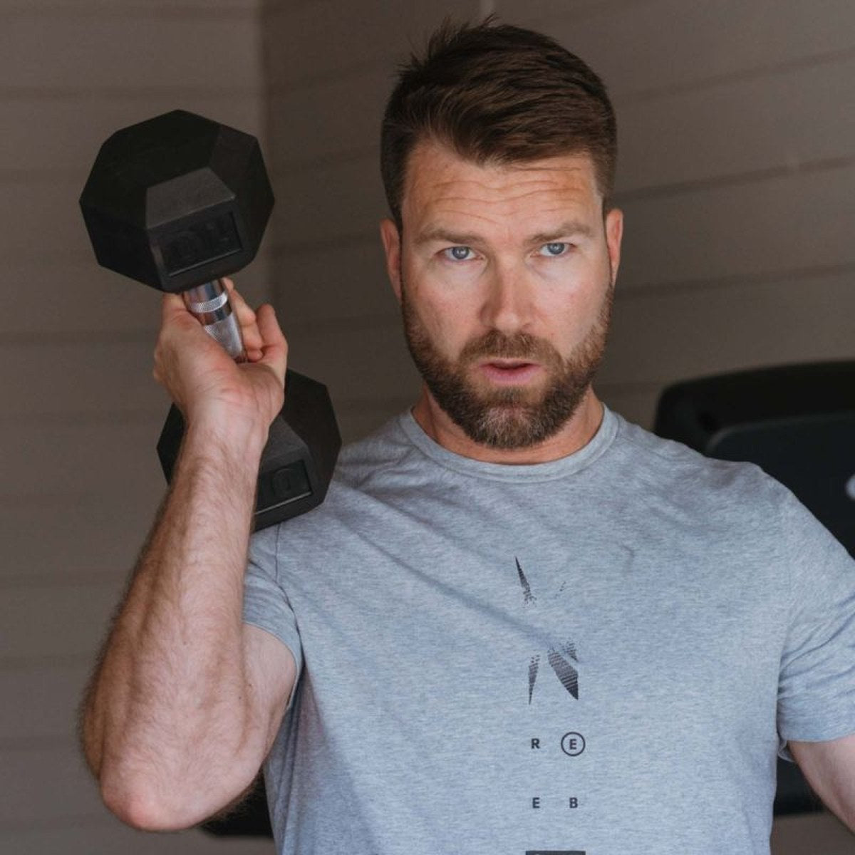 Mann som gjør bicepscurl med en tung manual
