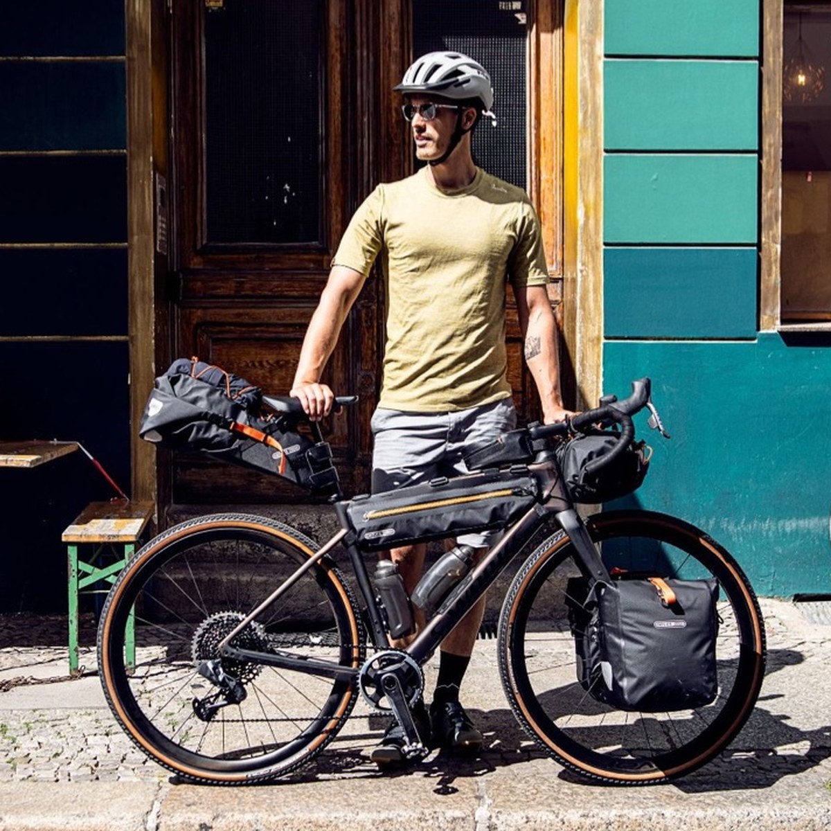 Syklist med Seat-Pack på grusykkel foran en kafé