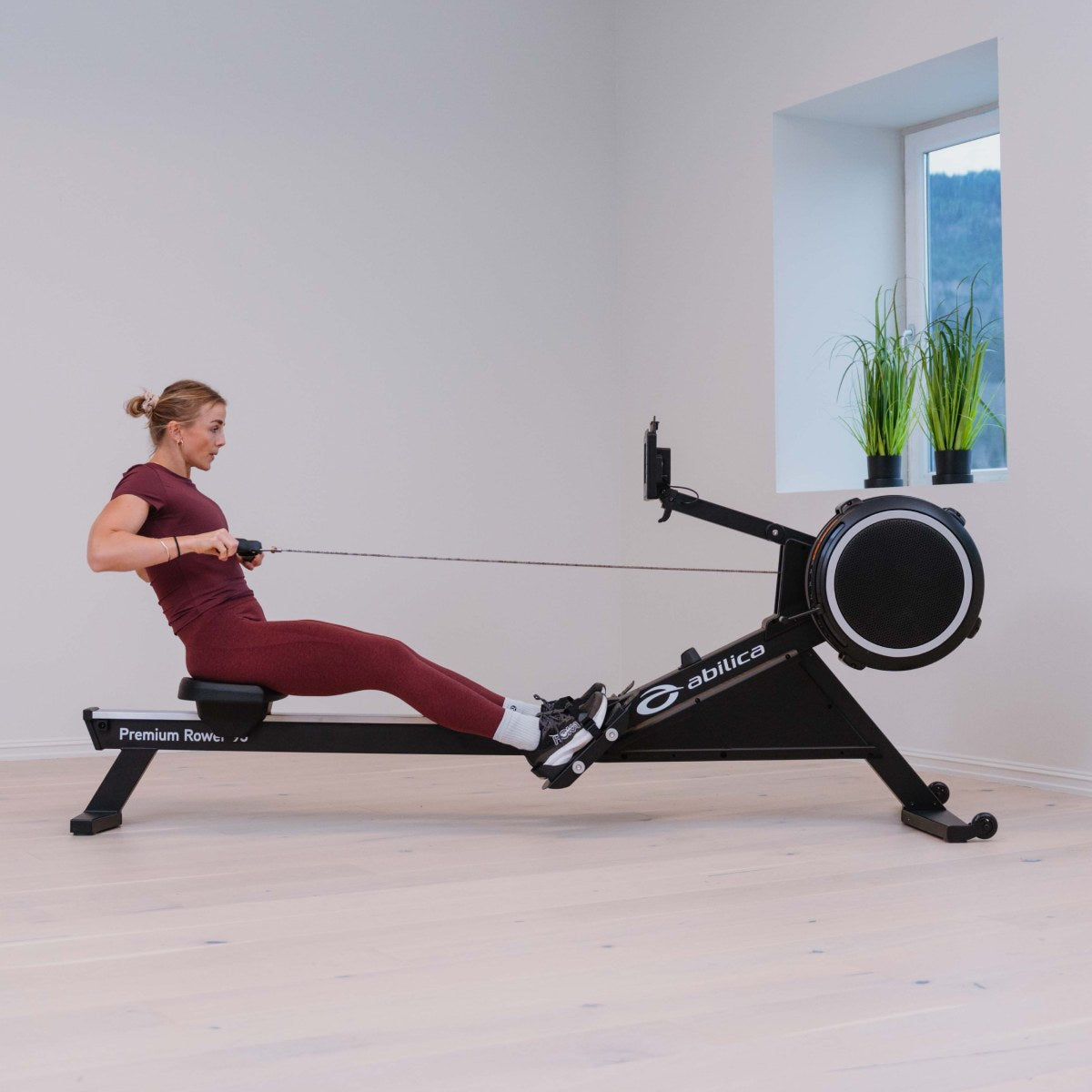 Kvinne som ror på Premium Rower 95