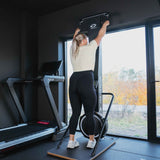 Kvinne som staker foran et stort vindu, sett bakfra