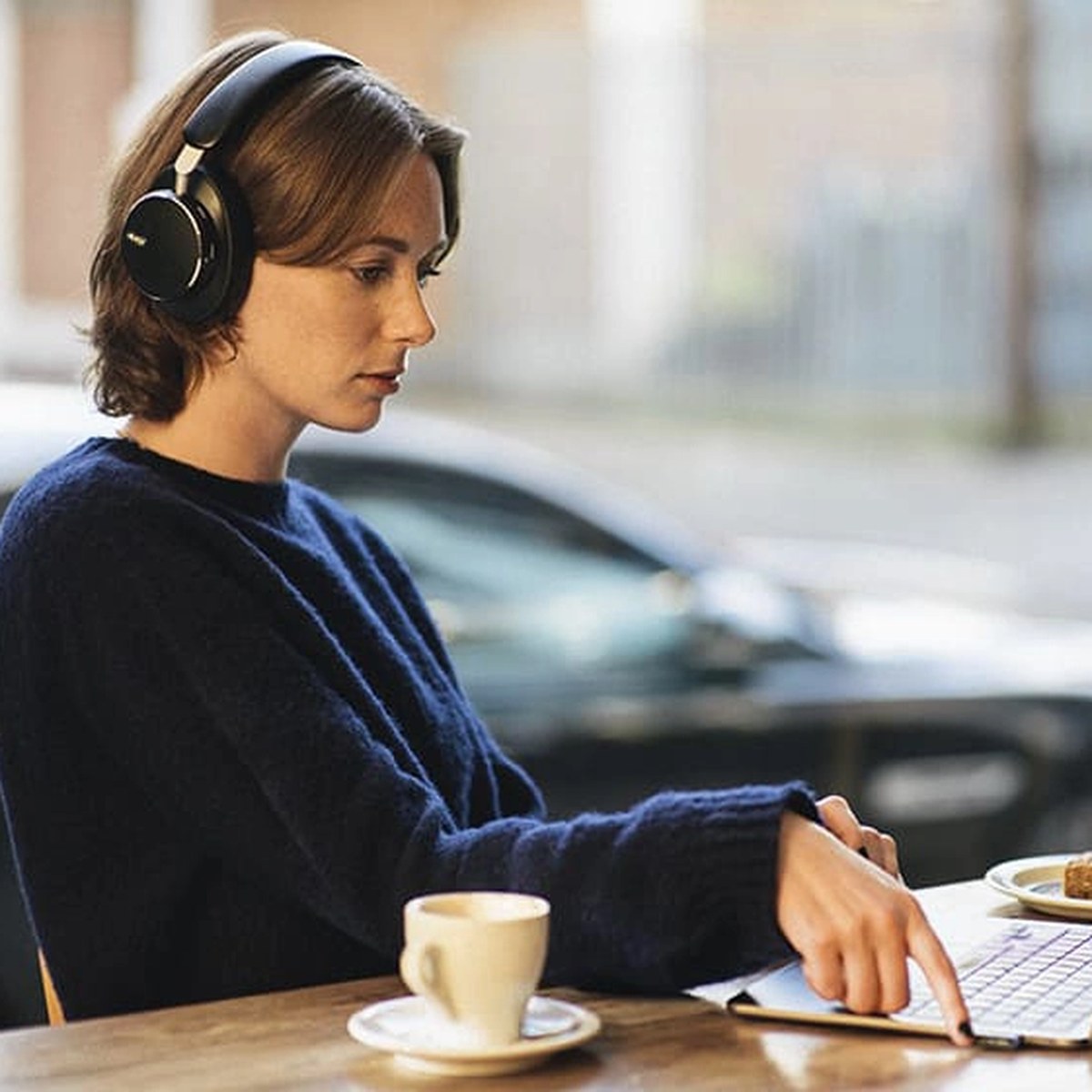 Kvinne med AKG N9 Hybrid på kafé