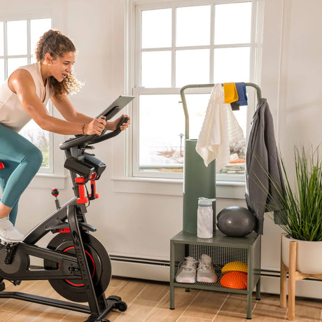 Kvinne som sykler på BowFlex C6 hjemme