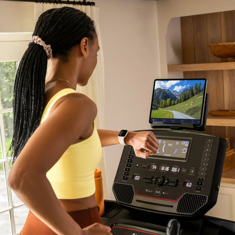 Kvinne som bruker konsollen på BowFlex T9 under trening