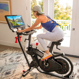 Kvinne som sykler på BowFlex VeloCore i et lyst rom
